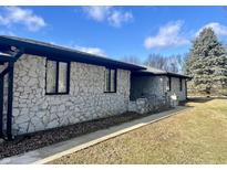 Ranch home with stone exterior, black accents, and a spacious yard at 816 N County Road 900 E, Avon, IN 46123