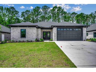 Modern craftsman style home with gray brick exterior, dark gray garage door, and a well-manicured lawn at 329 Spinney Dr., Little River, SC 29566