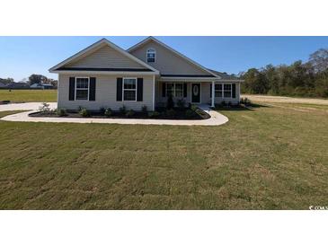 House exterior: Beige vinyl siding, black shutters, and a well-manicured lawn at 4189 Valley Forge Rd., Aynor, SC 29511