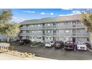 Exterior view of a multi-unit building with ample parking at 7700 Porcher Dr. # 3207, Myrtle Beach, SC 29572