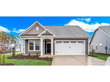 Gray craftsman style home with white garage door and landscaping at 3001 Deerberry Place, Longs, SC 29568