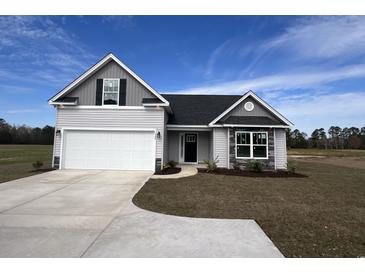 Two-story house with gray siding, white garage door and stone accents at 1424 Nathan Dr., Loris, SC 29569