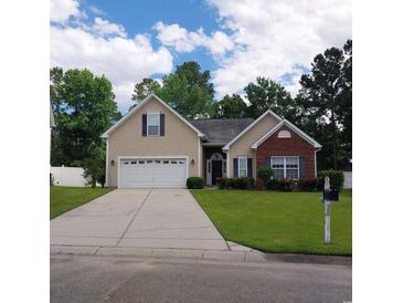 Tan brick house with two-car garage and landscaping at 173 Rocko Dr., Myrtle Beach, SC 29579