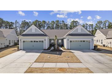 Two-story Craftsman style home with light gray siding, two-car garage, and mature landscaping at 5895 Cremona Dr., Myrtle Beach, SC 29577