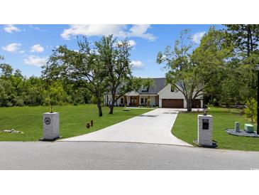 Beautiful two-story farmhouse with driveway and landscaping at 2192 Eastwoods Dr., Conway, SC 29526