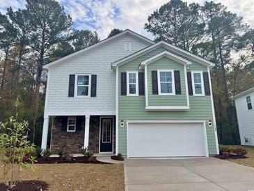 Two-story house with green and white siding, stone accents, and a two-car garage at 3327 Moss Bridge Ln., Myrtle Beach, SC 29579