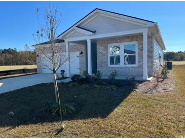 Newly constructed home with light brick exterior, two-car garage, and landscaped yard at 531 Cypress Preserve Circle, Longs, SC 29568