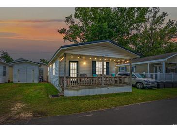 Charming cottage with a porch, string lights, and a yard at 6001-5137 S Kings Hwy., Myrtle Beach, SC 29575