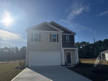 Two-story house with tan siding, white garage door, and landscaping at 499 Black Pearl Way, Myrtle Beach, SC 29588