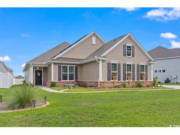 Tan house with a green lawn and landscaping at 5188 Country Pine Dr., Myrtle Beach, SC 29579