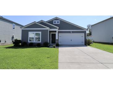 Gray house with white garage and green lawn at 163 Marsh Deer Place, Surfside Beach, SC 29575