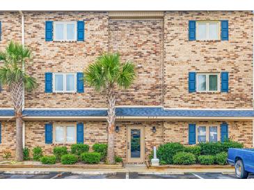 Brick building exterior with blue shutters and landscaping at 209 Double Eagle Dr. # H3, Surfside Beach, SC 29575