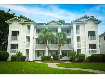 Three-story condo building with attractive landscaping and a walkway at 533 White River Dr. # 18D, Myrtle Beach, SC 29579