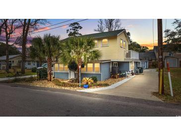 Two-story beach house with palm trees, a paved driveway, and a landscaped yard at 605 36Th Ave. S, North Myrtle Beach, SC 29582