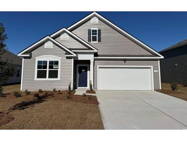 Charming two-story home with a two-car garage and landscaped lawn at 174 Calm Dr., Little River, SC 29566