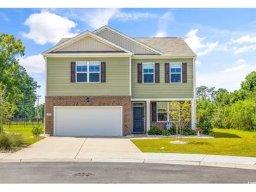 Two-story green house with brick and brown accents at 2945 Pegasus Place, Myrtle Beach, SC 29577