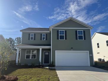 Two-story house with green siding, white garage door, and landscaping at 545 Black Pearl Way, Myrtle Beach, SC 29588