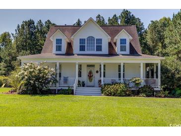 Two-story home with white siding, brown roof, and a large front porch at 5356 Hamps Rd., Nichols, SC 29581