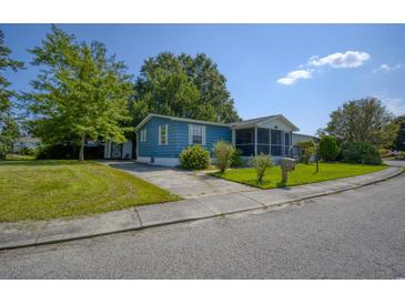 Blue house with a screened porch and landscaped yard at 1119 Blue Ridge Trail, North Myrtle Beach, SC 29582