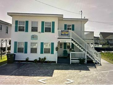 Two-story beach house with teal accents and a staircase at 329 54Th Ave. N, North Myrtle Beach, SC 29582