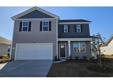 Two-story home with gray siding, white garage door, and landscaping at 192 Hadley Springs Ave, Longs, SC 29568