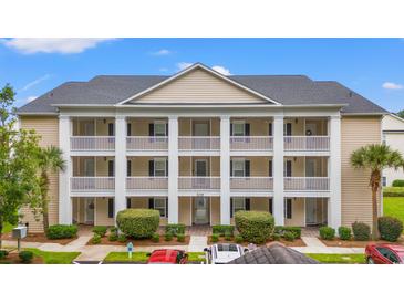 Two-story condo building with columns, balconies, and ample parking at 631 Woodmoor Dr. # 303, Murrells Inlet, SC 29576