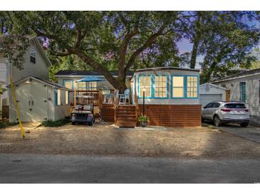 Cute cottage with deck, golf cart, and storage shed. Landscaped yard and spacious driveway at 6001 - 1864A S Kings Hwy., Myrtle Beach, SC 29575