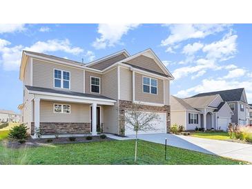 Two-story house with beige siding, stone accents, and a two-car garage at 357 Glacier Way, Conway, SC 29526