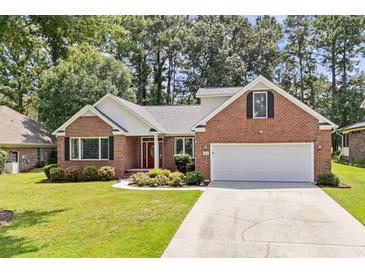 Brick home with two-car garage and landscaped front yard at 3420 Cedar Creek Run, Little River, SC 29566