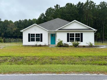 White house with teal door, black windows, and green lawn at 1884 Mount Zion Rd., Loris, SC 29569