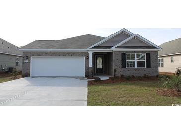 Brick front exterior of charming one-story house with attached garage and landscaped lawn at 815 Hibernation Way, Conway, SC 29526