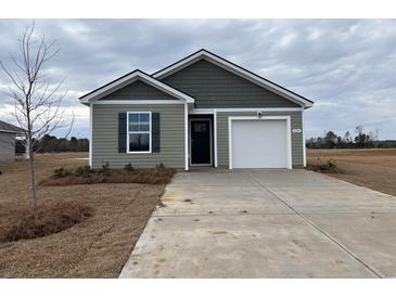 Newly constructed home with gray siding, white garage door, and landscaping at 824 Buttonwood Dr., Conway, SC 29527