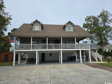 Two-story house with a large deck, ample parking, and a spacious yard at 710 Lakeside Dr., Surfside Beach, SC 29575