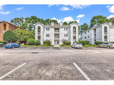 Three-story building with parking lot and landscaping at 4255 Villas Dr. # 201, Little River, SC 29566