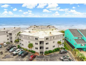 Oceanfront condo building with parking and surrounding homes at 6302 Ocean Blvd. N # E-1, North Myrtle Beach, SC 29582