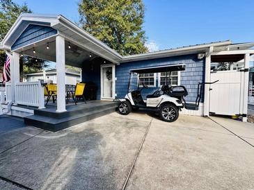 Blue cottage with covered porch, golf cart, and outdoor shower at 6001 - N21 S Kings Hwy., Myrtle Beach, SC 29575