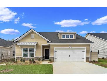 Tan house with white garage door and landscaping at 5042 Selene Ct., Myrtle Beach, SC 29588