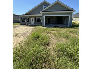 Newly constructed home with gray siding, a two-car garage, and landscaping at 4485 Privetts Rd., Conway, SC 29526