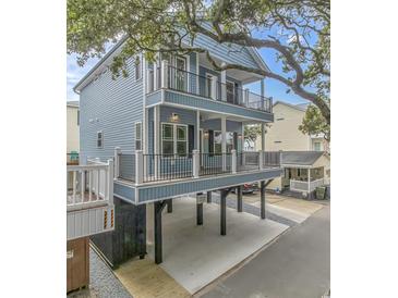 Two-story light blue house with deck, parking underneath, and mature trees at 6001-1122A S Kings Hwy., Myrtle Beach, SC 29575