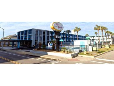 Wave Rider Motel exterior view, featuring a pool, palm trees, and ample parking at 1600 S Ocean Blvd. # 114, Myrtle Beach, SC 29577