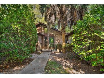 Brick house with a walkway, lush landscaping, and a gated entry at 19 South Gate Rd., Myrtle Beach, SC 29572