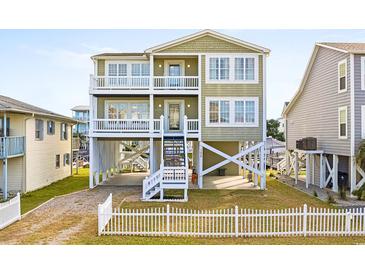 Elevated two-story home with white picket fence at 108 Burlington St. W, Holden Beach, NC 28462