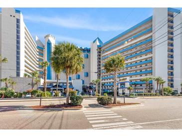 Oceanfront resort building with palm trees and walking path at 7100 N Ocean Blvd. # 913, Myrtle Beach, SC 29572