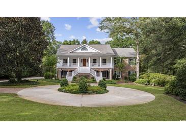 Two-story brick home with circular driveway and landscaped yard at 4400 Saint Andrews Ct., Murrells Inlet, SC 29576