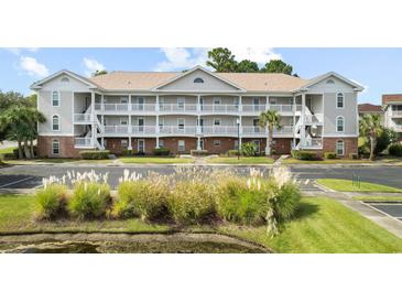 Two-story condo building with ample parking and lush landscaping at 5750 Oyster Catcher Dr. # 1134, North Myrtle Beach, SC 29582