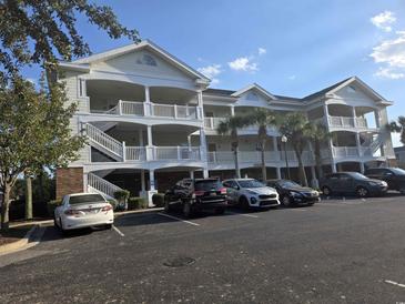Three-story building exterior with parking lot at 5801 Oyster Catcher Dr. # 413, North Myrtle Beach, SC 29582