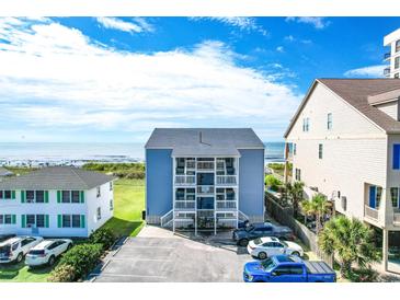Oceanfront view of a three-story building with parking and beach access at 4105 S Ocean Blvd. S # 102, North Myrtle Beach, SC 29582