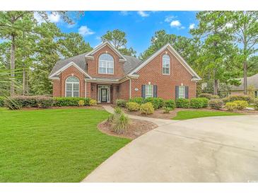 Brick house with manicured lawn and circular driveway at 676 Oxbow Dr., Myrtle Beach, SC 29579