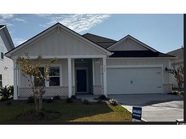 Charming one-story home with a covered porch and landscaped lawn at 8605 Pinnacle Cove Way, Longs, SC 29568