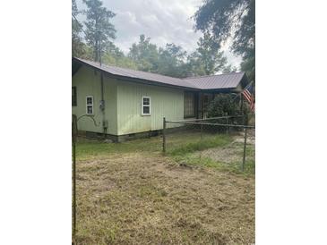 Light green house with brown roof and American flag at 708 Grices Ferry Ct., Mullins, SC 29574
